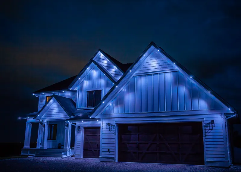 A home lit in cool blue along every roofline and gable
