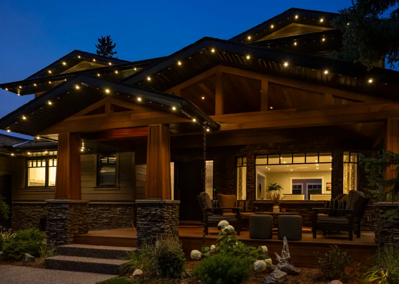 Warm lighting following the deep eaves of a craftsman porch