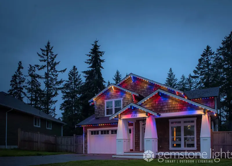 Multicolor Christmas on a craftsman with tall pines behind