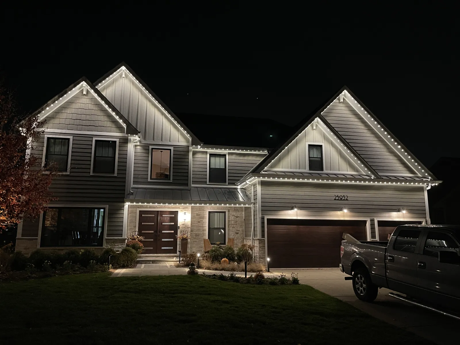 Two-story house with bright white light along every roofline